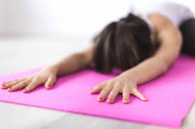 woman stretching on yoga mat