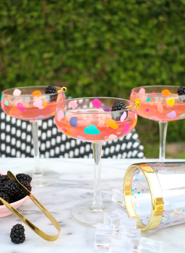 glasses with stems and decorated with confetti on table