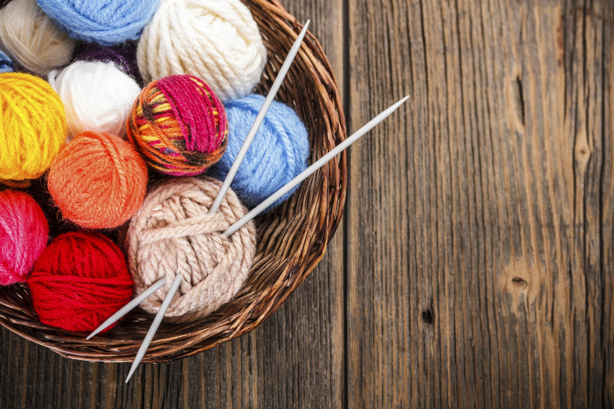 basket with colorful yarn and needles