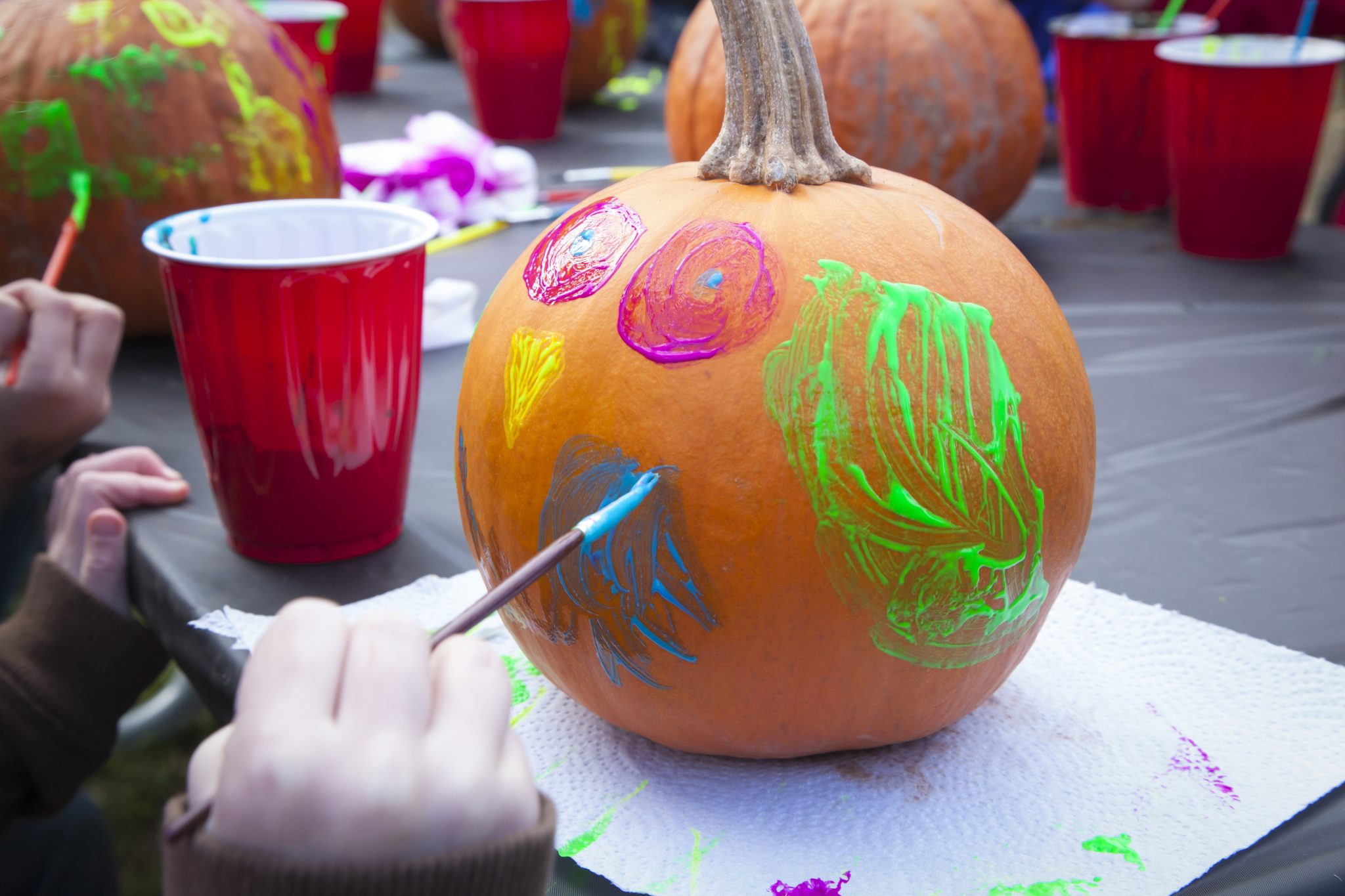 child painting a pumpkin