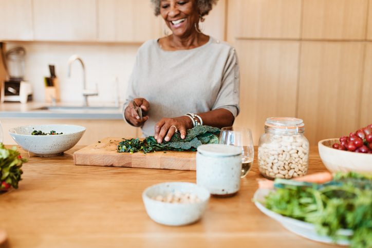Woman in her kitchen, preparing green leafy vegetables