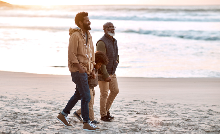 Photo of two men walking on a beach.