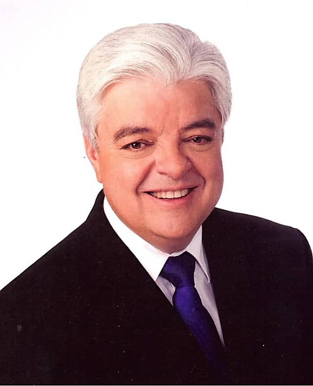 Joe Rao in black suit and purple tie against white background