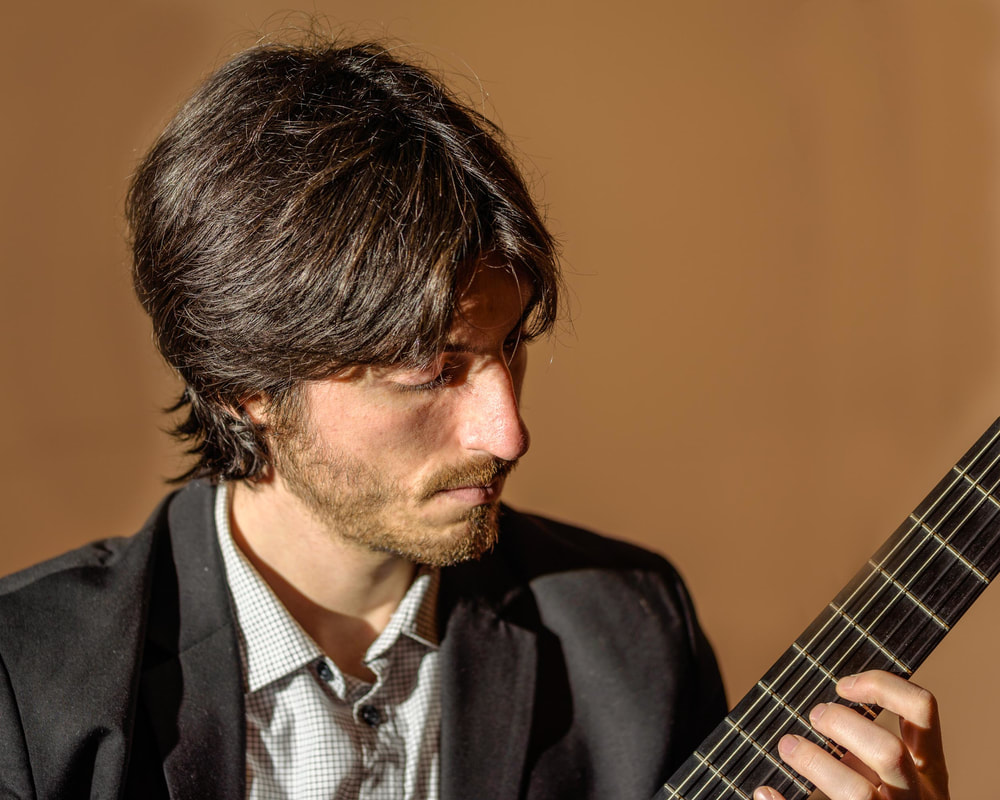 Gentleman looking at this guitar against a brown background