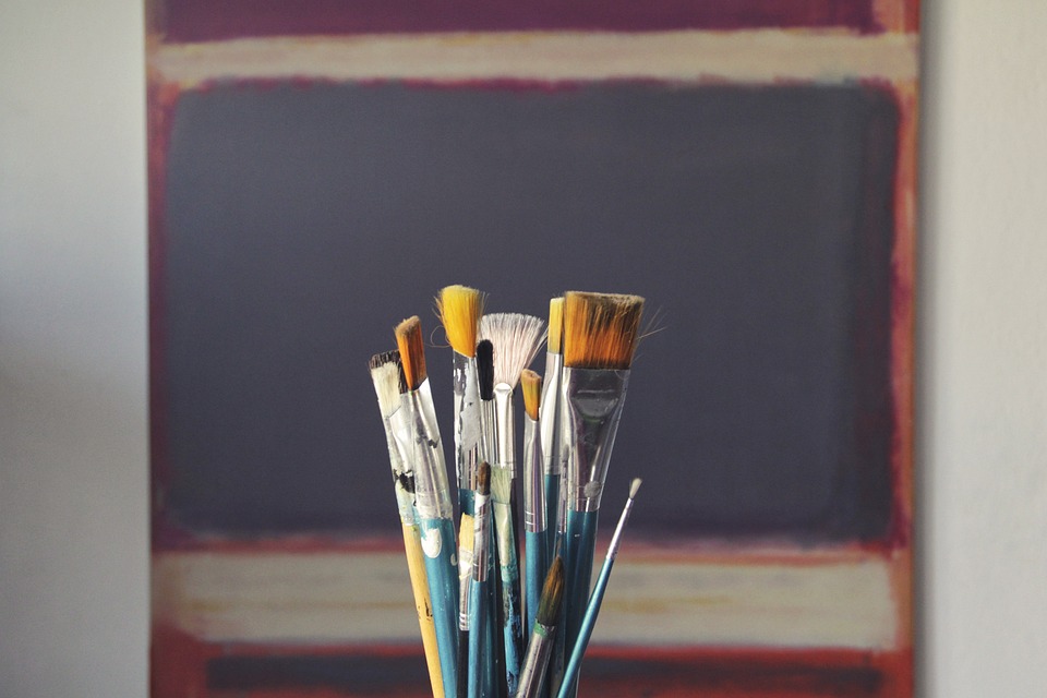 paint brushes in front of a black chalk board