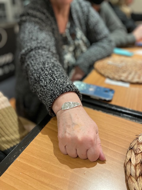 outstretched older person's hand and wrist to show off bracelet. 