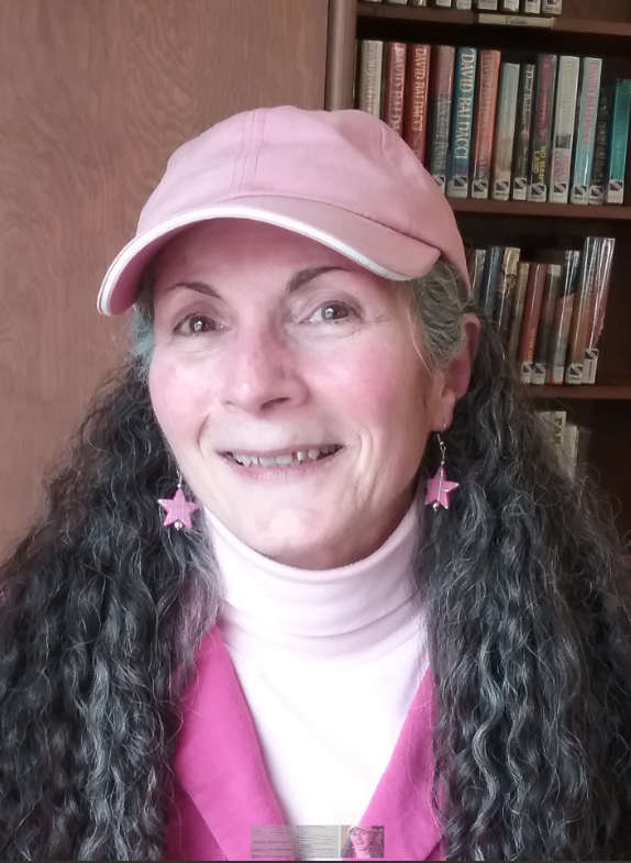 a woman with star earrings and a pink hat