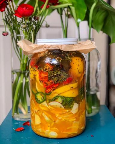 jar of fire cider with roses on table 