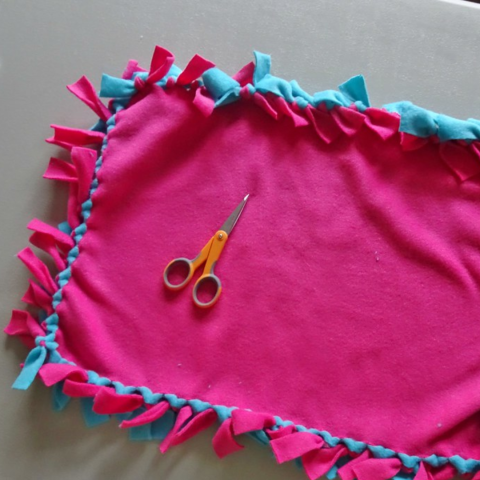 Pink and Blue fleece tied together to make a no-sew pillow.