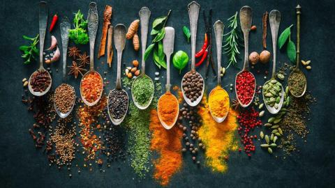 a picture of several spoons lined up and full of different herbs and spices