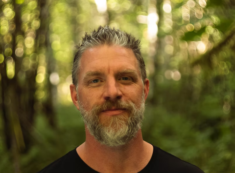 A man's face with a blurred out forest background, Ronny LeBlanc