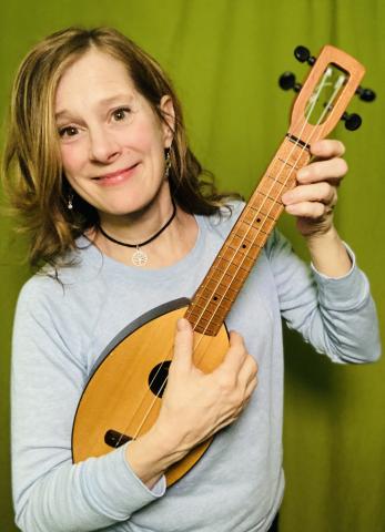photo of Julie Stepanek smiling and holding a ukulele