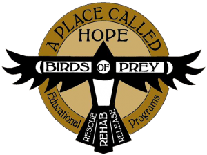 The logo for A Place Called Hope with two different sized golden circles fitting within each other and a stylized bird on top which has the words Birds of Prey across the wings and the words Rescue, Release, and Rehab on the tail feathers. On the bottom of the circle has the words Educational Programs.